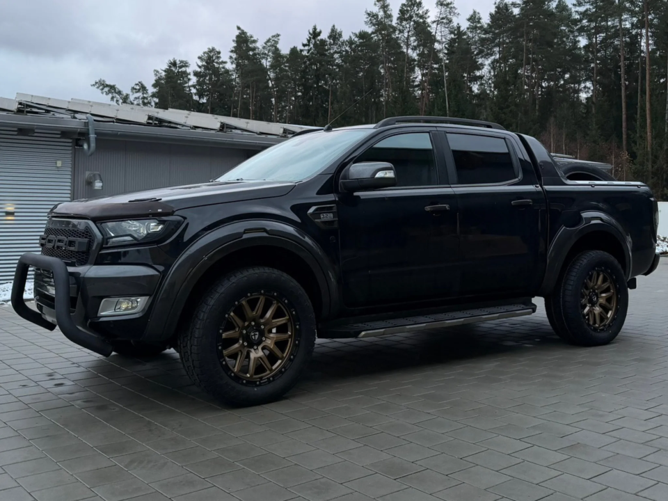 Schwarzer Pick-up mit Bronze-Felgen in einer Hofeinfahrt.